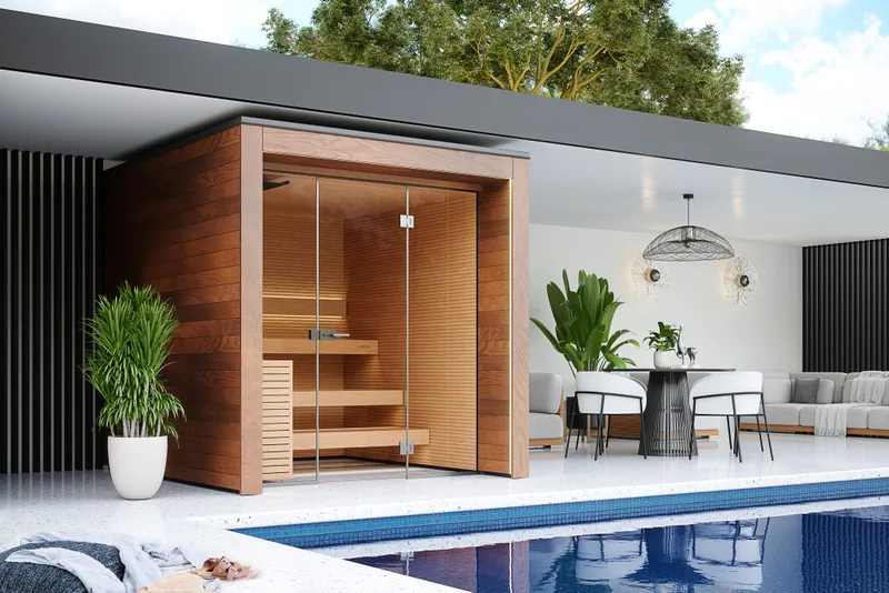 A glass-fronted sauna beside a still pool