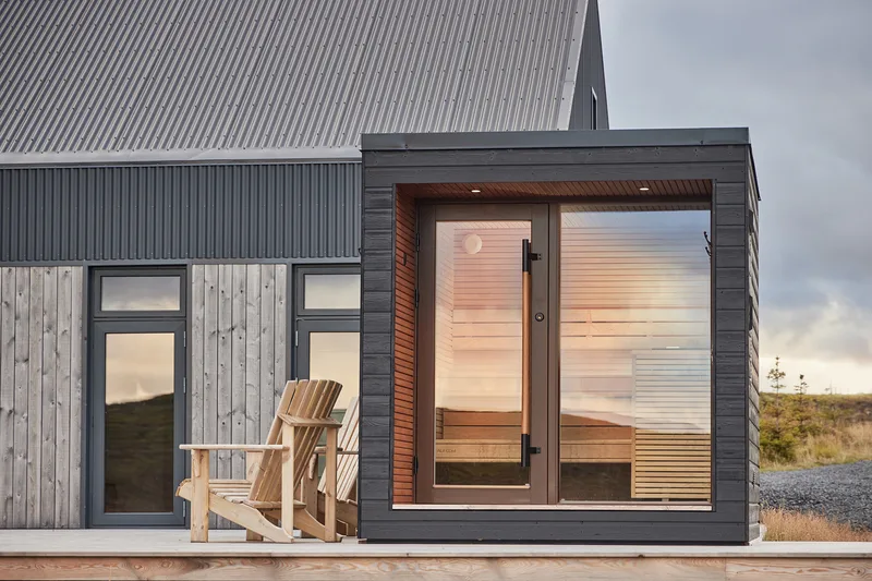 Arti outdoor sauna beside a home in an open landscape